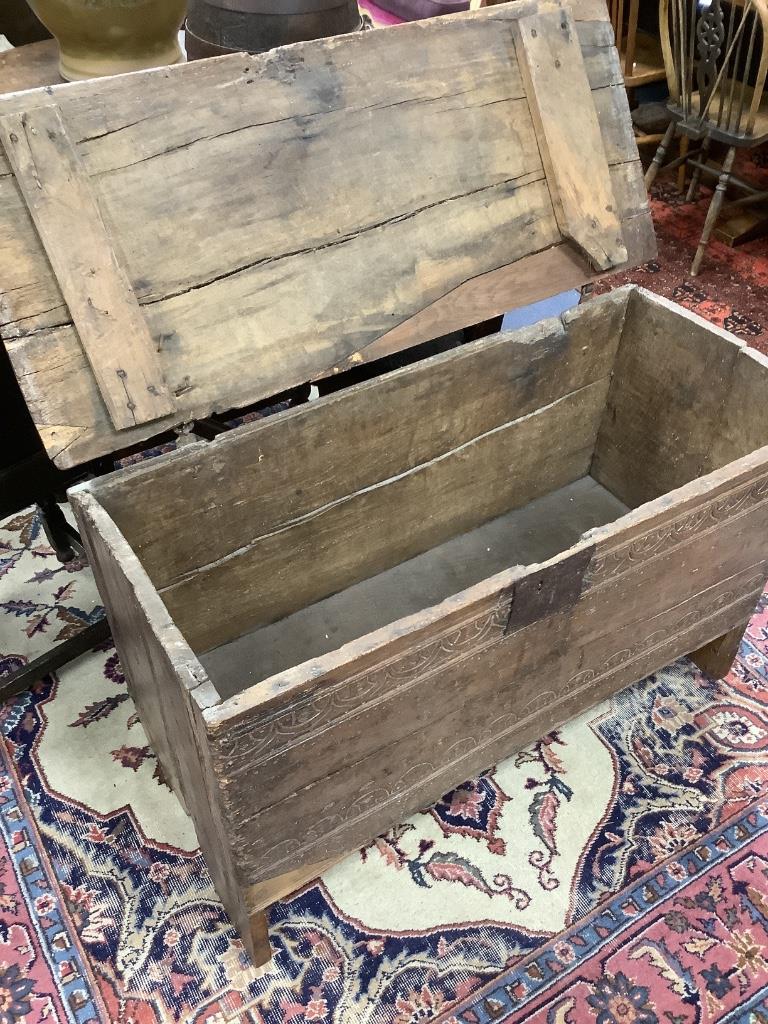 An early English oak six plank coffer, with shallow incised roundels and arched borders, 17th century, width 114cm, depth 50cm, height 72cm